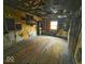 Dilapidated bedroom reveals wall framing and exposed ceiling rafters at 359 W 26Th St, Indianapolis, IN 46208