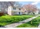 Beautiful two-story house with stone details, a blue front door, green lawn and mature trees at 3738 Barrington Dr, Carmel, IN 46033