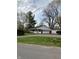Charming ranch-style home featuring an attached garage, brick details, white siding, and a cozy porch at 4290 Manning Rd, Indianapolis, IN 46228