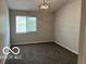 This bedroom has neutral walls, carpet, and a modern chandelier for comfortable living at 4311 Village Parkway W Cir # 6, Indianapolis, IN 46254