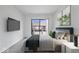 A cozy bedroom featuring a plush bed, a mounted TV, and lots of natural light at 456 E Arch St, Indianapolis, IN 46202