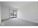 A spacious bedroom with neutral carpet and sliding glass doors to balcony with backyard views at 456 E Arch St, Indianapolis, IN 46202