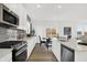 Bright kitchen showcasing stainless steel appliances, a gray backsplash, white cabinets, and an adjacent dining area at 5311 Pelion Pl, McCordsville, IN 46055