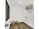 Bright laundry room with wood-look flooring, shelving, and wicker baskets for storage solutions at 5311 Pelion Pl, McCordsville, IN 46055
