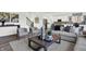 Cozy living room featuring modern furniture, neutral decor, an area rug, and an open view into the kitchen at 5311 Pelion Pl, McCordsville, IN 46055