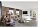 Bright living room with a stylish sectional, wood accent wall, and modern glass coffee table at 5311 Pelion Pl, McCordsville, IN 46055
