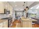 Bright kitchen showcasing stainless steel appliances, a center island with seating, and dining room view at 5348 Ashby Ct, Greenwood, IN 46143