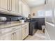 Charming laundry room with granite countertops, stylish cabinets, wallpaper accents, and modern appliances at 5348 Ashby Ct, Greenwood, IN 46143