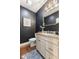 Elegant powder room featuring a decorative mirror, vanity with granite countertop, and dark accent walls at 5348 Ashby Ct, Greenwood, IN 46143