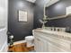 Modern powder room with a dark wall, granite countertop, and a stylish vanity at 5348 Ashby Ct, Greenwood, IN 46143