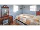 Light bedroom with matching antique dresser and mirror, queen bed and colorful quilted bedding at 575 Everling Dr, Morgantown, IN 46160
