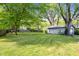 Spacious, grassy backyard featuring a storage shed and lush trees at 5817 Beechwood Ave, Indianapolis, IN 46219