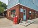 A charming building exterior featuring brickwork, large windows, and a light blue door with steps leading up to it at 5817 Beechwood Ave, Indianapolis, IN 46219