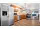 Modern kitchen with stainless steel appliances, wood cabinets, and an open view to the living area at 5817 Beechwood Ave, Indianapolis, IN 46219