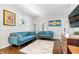 Comfortable living room featuring blue sofas, hardwood floors, and a cheerful, patterned rug at 5817 Beechwood Ave, Indianapolis, IN 46219