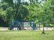 A blue and white playground is surrounded by lush green grass and mature trees at 5817 Beechwood Ave, Indianapolis, IN 46219