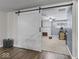 Bonus room showcases stylish sliding barn door, ceiling fan, and view of whitewashed brick fireplace at 6827 S 500 W, Trafalgar, IN 46181