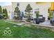 This backyard features a large stone patio seating area with mature shade trees and a manicured lawn at 701 Danver Ln, Beech Grove, IN 46107