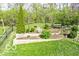 Landscaped backyard with stone-walled garden beds, ornamental trees, lush lawn, and perimeter fence at 701 Danver Ln, Beech Grove, IN 46107