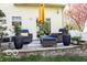 This backyard features a stone patio seating area with modern outdoor furniture and mature shade trees at 701 Danver Ln, Beech Grove, IN 46107
