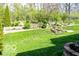 Extensive landscaped backyard featuring terraced garden beds, mature trees, and lush green lawn at 701 Danver Ln, Beech Grove, IN 46107