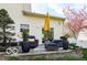 This backyard features a stone patio seating area with modern outdoor furniture and mature shade trees at 701 Danver Ln, Beech Grove, IN 46107