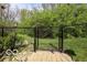 Backyard entrance featuring gate enclosed by mature landscaping and stone pathway at 701 Danver Ln, Beech Grove, IN 46107