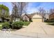 Well-maintained home featuring a two-car garage, brick detailing, and a lush front yard with mature landscaping at 701 Danver Ln, Beech Grove, IN 46107