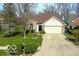 Inviting home with lush lawn, mature trees, and a driveway leading to an attached two-car garage at 701 Danver Ln, Beech Grove, IN 46107