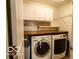 Convenient laundry room with modern washer and dryer, featuring overhead cabinets at 701 Danver Ln, Beech Grove, IN 46107