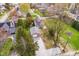 Rear aerial view showcasing the home, detached garage, gravel driveway, and mature trees at 702 S Fanning St, Sheridan, IN 46069