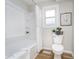 Bright bathroom featuring a white tub and shower combination, a window, and decorative accents at 702 S Fanning St, Sheridan, IN 46069