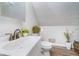 Bathroom with a modern sink, toilet, and decorative plants, complemented by wood-look flooring at 702 S Fanning St, Sheridan, IN 46069