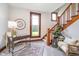 Bright foyer with a staircase, large clock and a comfortable chair; an inviting view of the home's interior at 702 S Fanning St, Sheridan, IN 46069