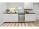 Efficient kitchen with white cabinets, stainless steel dishwasher, and a view of natural light through the window at 702 S Fanning St, Sheridan, IN 46069