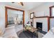 Open-concept living room featuring a fireplace, wood trim, and dining room view at 702 S Fanning St, Sheridan, IN 46069
