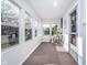Bright sunroom with multiple windows, neutral decor, and cozy seating area at 702 S Fanning St, Sheridan, IN 46069