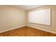 Bedroom with hardwood floors, neutral walls, and white shuttered window at 7023 Steinmeier W Dr, Indianapolis, IN 46220