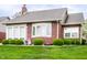 A well-maintained brick home with a large lawn and mature landscaping creates a welcoming atmosphere at 7023 Steinmeier W Dr, Indianapolis, IN 46220