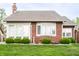 A charming brick home with a manicured lawn and rounded hedges offers classic curb appeal at 7023 Steinmeier W Dr, Indianapolis, IN 46220