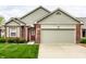 Charming brick home features a two-car garage, a well-maintained lawn, and painted siding at 7023 Steinmeier W Dr, Indianapolis, IN 46220