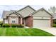 Charming brick home featuring a two-car garage, a well-maintained lawn, and painted siding at 7023 Steinmeier W Dr, Indianapolis, IN 46220