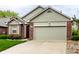 Charming brick home featuring a two-car garage, a well-maintained lawn, and muted green siding at 7023 Steinmeier W Dr, Indianapolis, IN 46220
