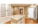 Kitchen island with granite countertop, white cabinets, and hardwood floors open to the adjacent room at 7023 Steinmeier W Dr, Indianapolis, IN 46220