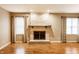 Spacious living room featuring hardwood floors, a fireplace, and ample natural light from large windows at 7023 Steinmeier W Dr, Indianapolis, IN 46220