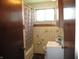 Bathroom with a shower-tub combo, light tile and grab bars at 7402 Alice Ave, Indianapolis, IN 46219