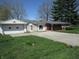 Quaint home featuring a front porch, chimney, detached garage, and well-maintained lawn at 7402 Alice Ave, Indianapolis, IN 46219