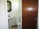 Powder room featuring a pedestal sink, toilet, and neutral decor at 7402 Alice Ave, Indianapolis, IN 46219