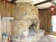 Living room with wood paneling, stone fireplace, tile floors, and vintage-style lighting fixtures at 7402 Alice Ave, Indianapolis, IN 46219