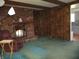 Cozy living room featuring a brick fireplace, wood paneling, and comfortable seating at 7402 Alice Ave, Indianapolis, IN 46219